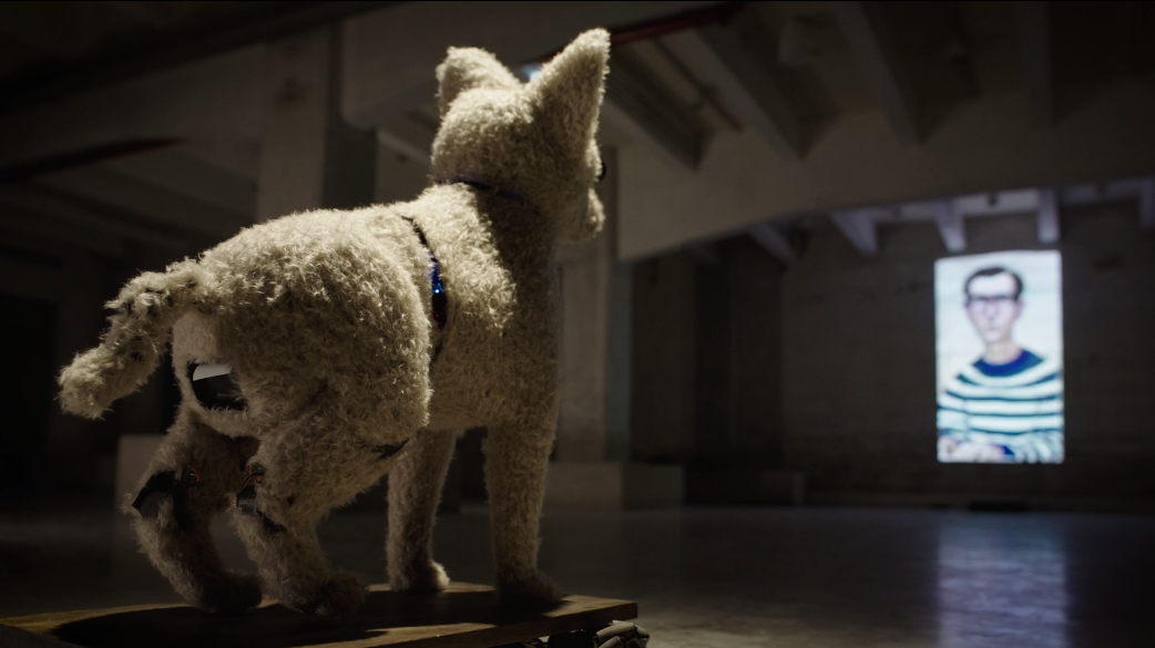 A.I.C.C.A. vs. Portrait of a man (75 years old) in a horizontally blue-white thinly-striped french breton jumper wearing square square square cornered rectangular black rim designer glasses and greying short straight hair parting hairstyle, oil on canvas (1991)